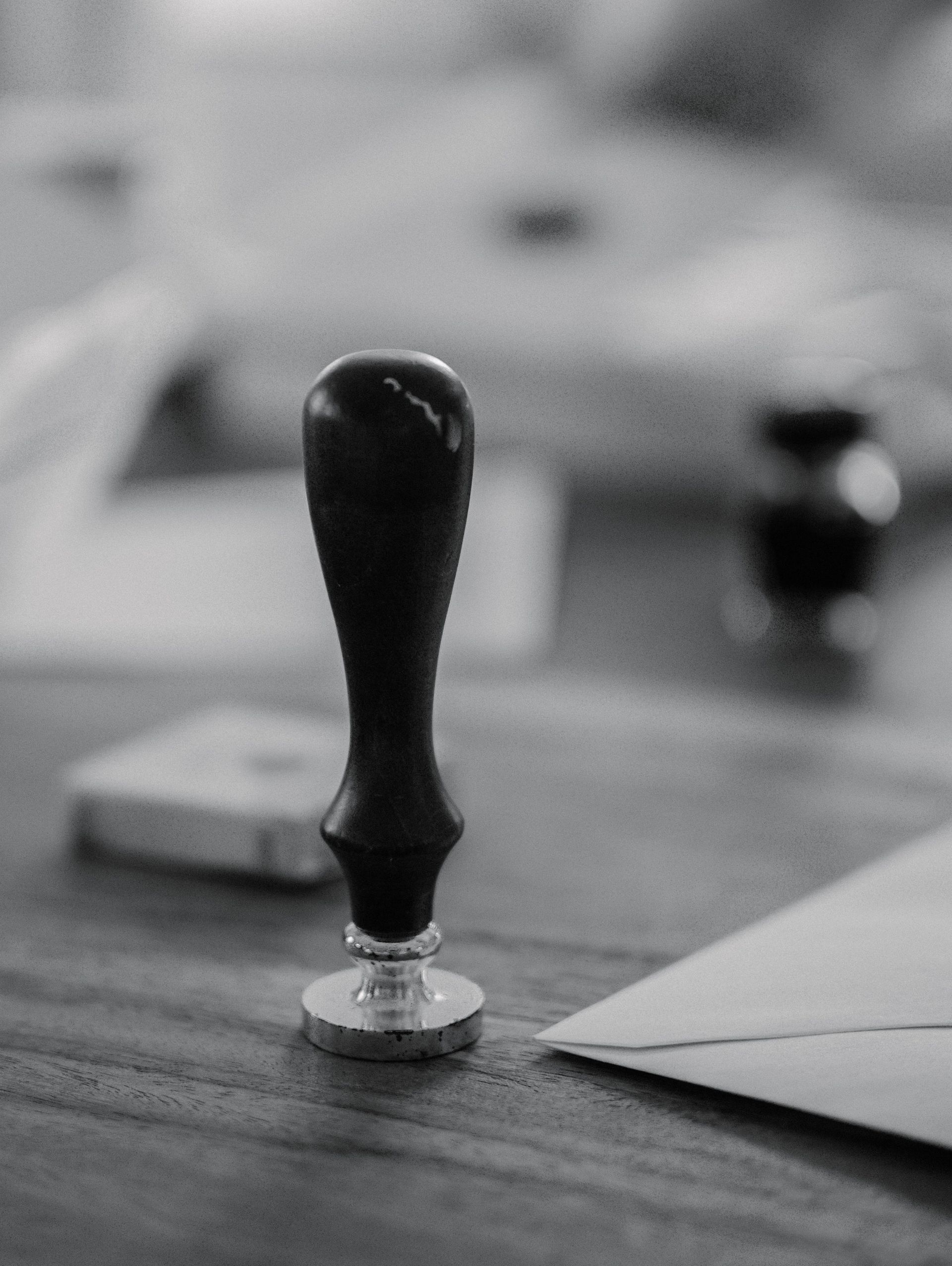 Black and white image of a traditional wax seal with an envelope.